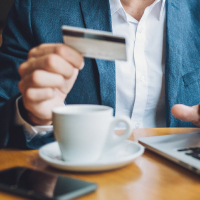 a man holding a debit card at coffee shop