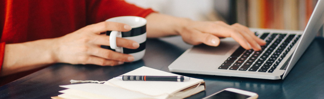 woman typing on laptop with coffee