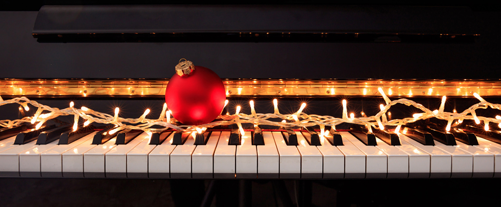 christmas lights and ornament on piano keys